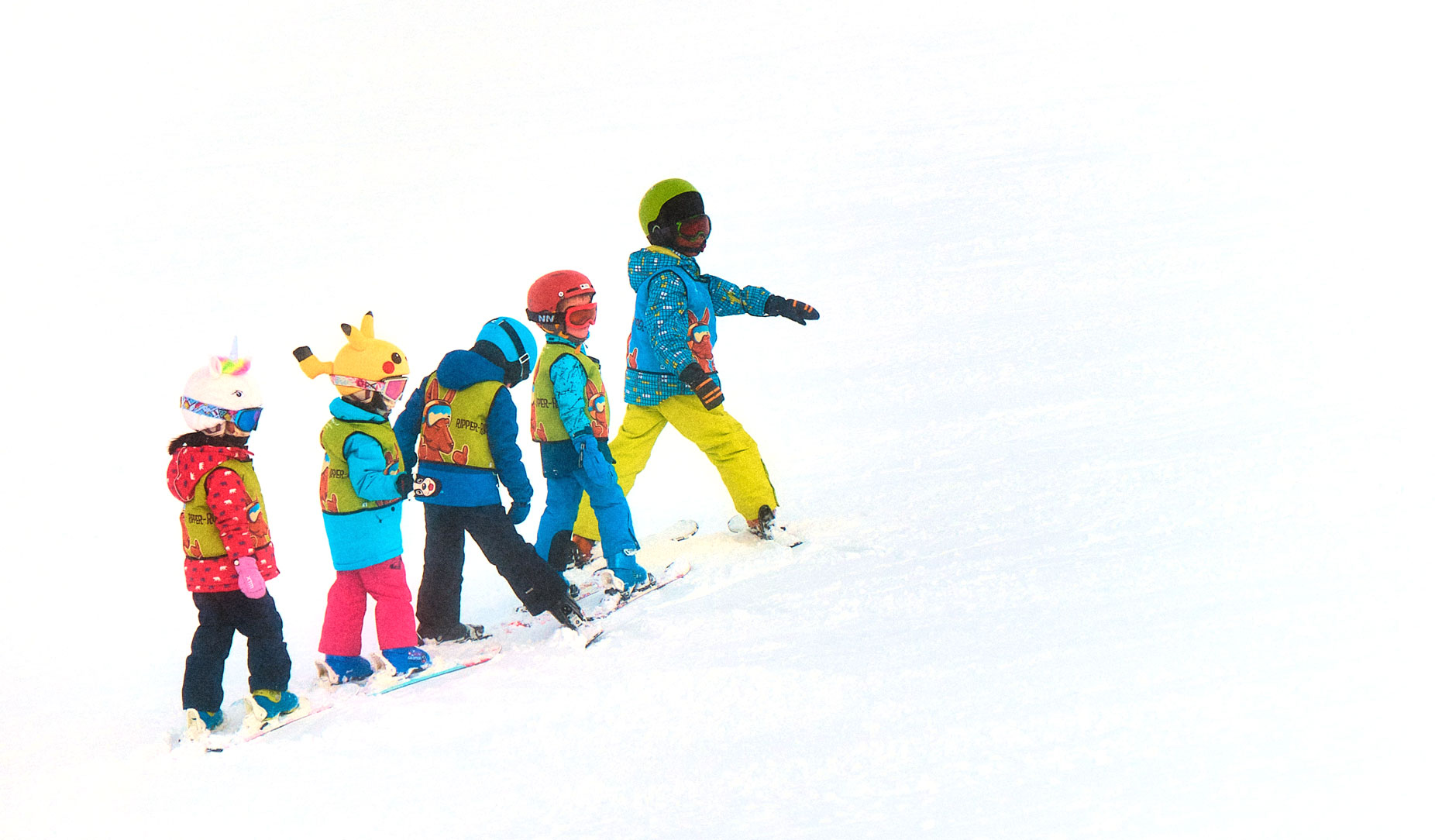 Kids walking uphill on the snow in skis